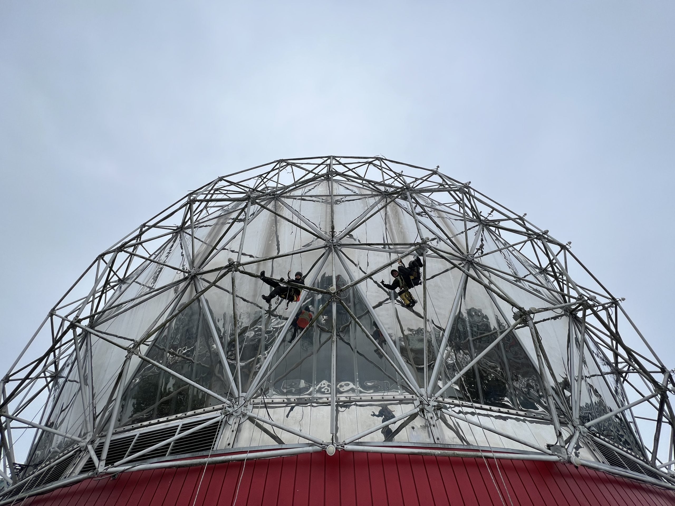Two Rope Access technicians Hang from the structure on the Science World Dome Repairing Lights